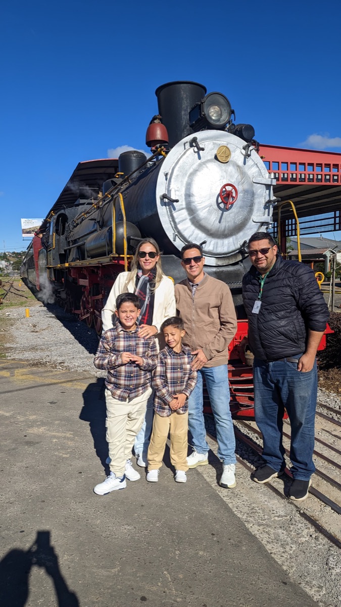 Família com o Rafa Tour em frente à locomotiva Maria Fumaça em Bento Gonçalves